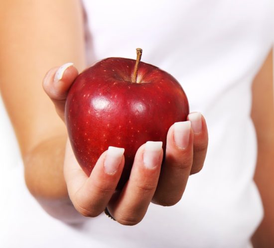 woman holding red apple in her hand