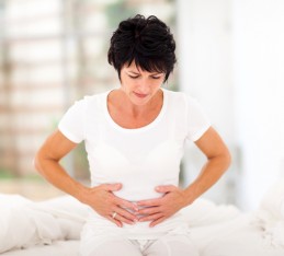 Hard to digest foods, worst foods for digestion: woman holding stomach in digestive pain