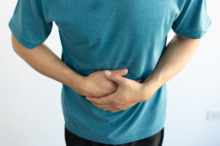 Gastritis Dietitian and Nutritionist man holding his stomach in pain needing the help of a gastritis dietitian and nutritionist